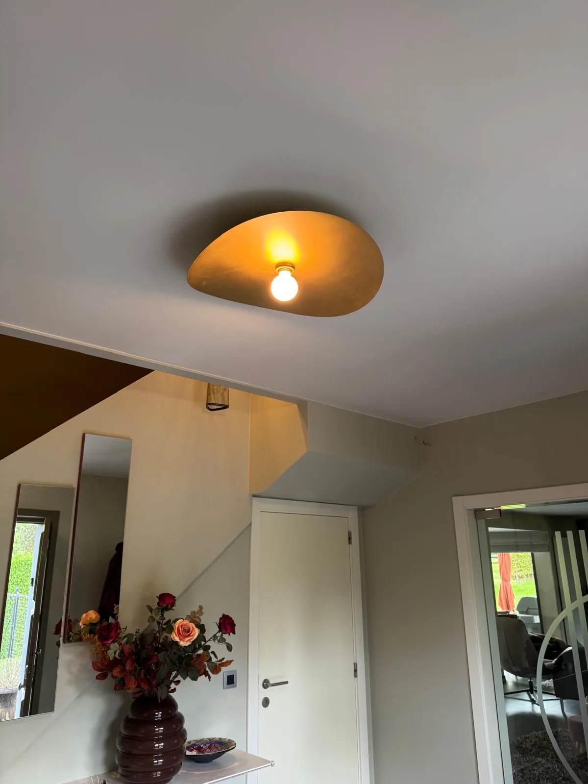 Organische goudkleurige plafondlamp met een blote gloeilamp voor warme sfeerverlichting