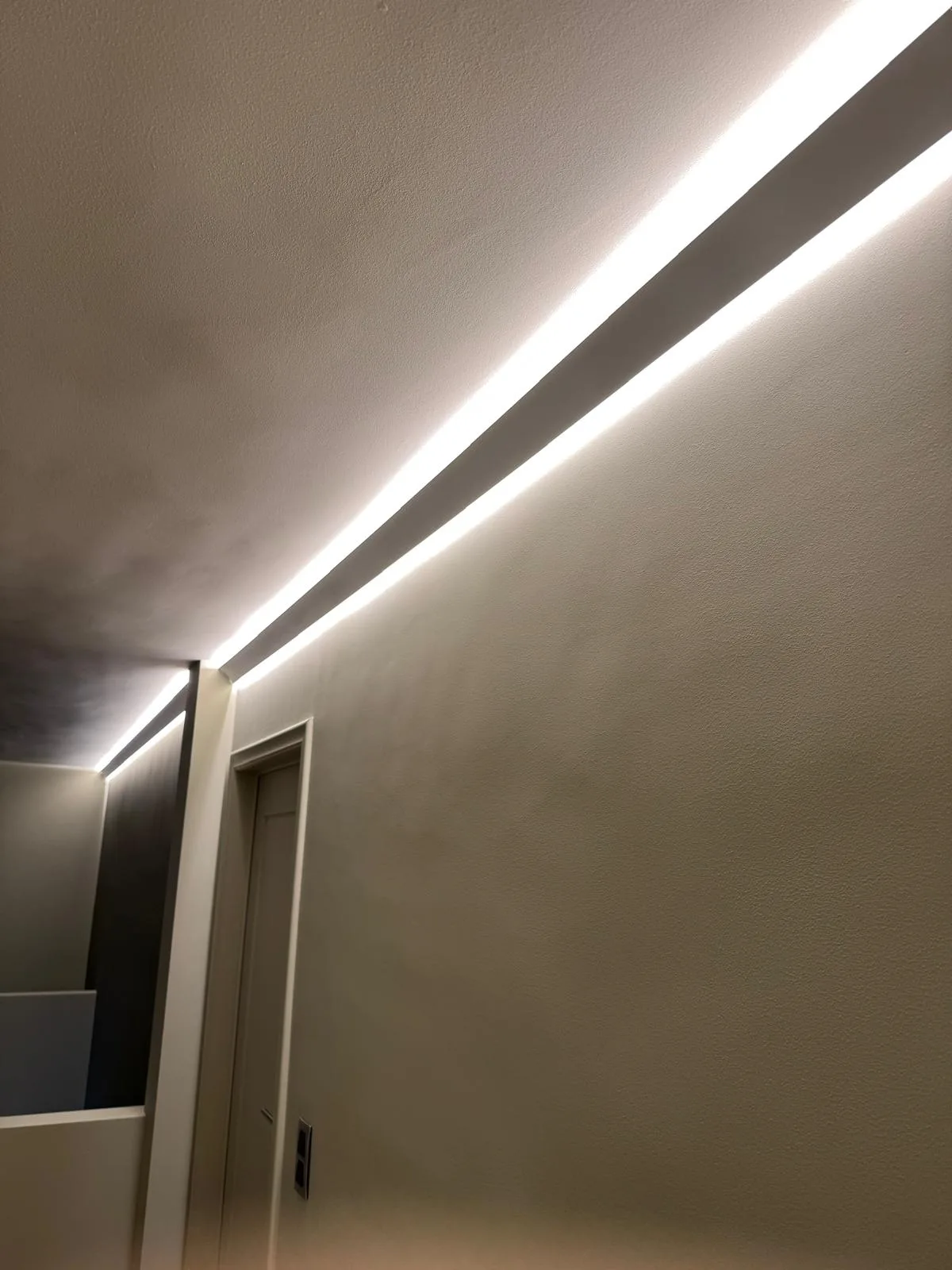 Detail van ingewerkte LED-lijnverlichting in de plafondrand tijdens de afwerking